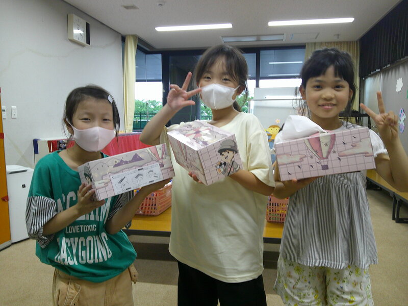 子ども達がティッシュ箱を持っています。